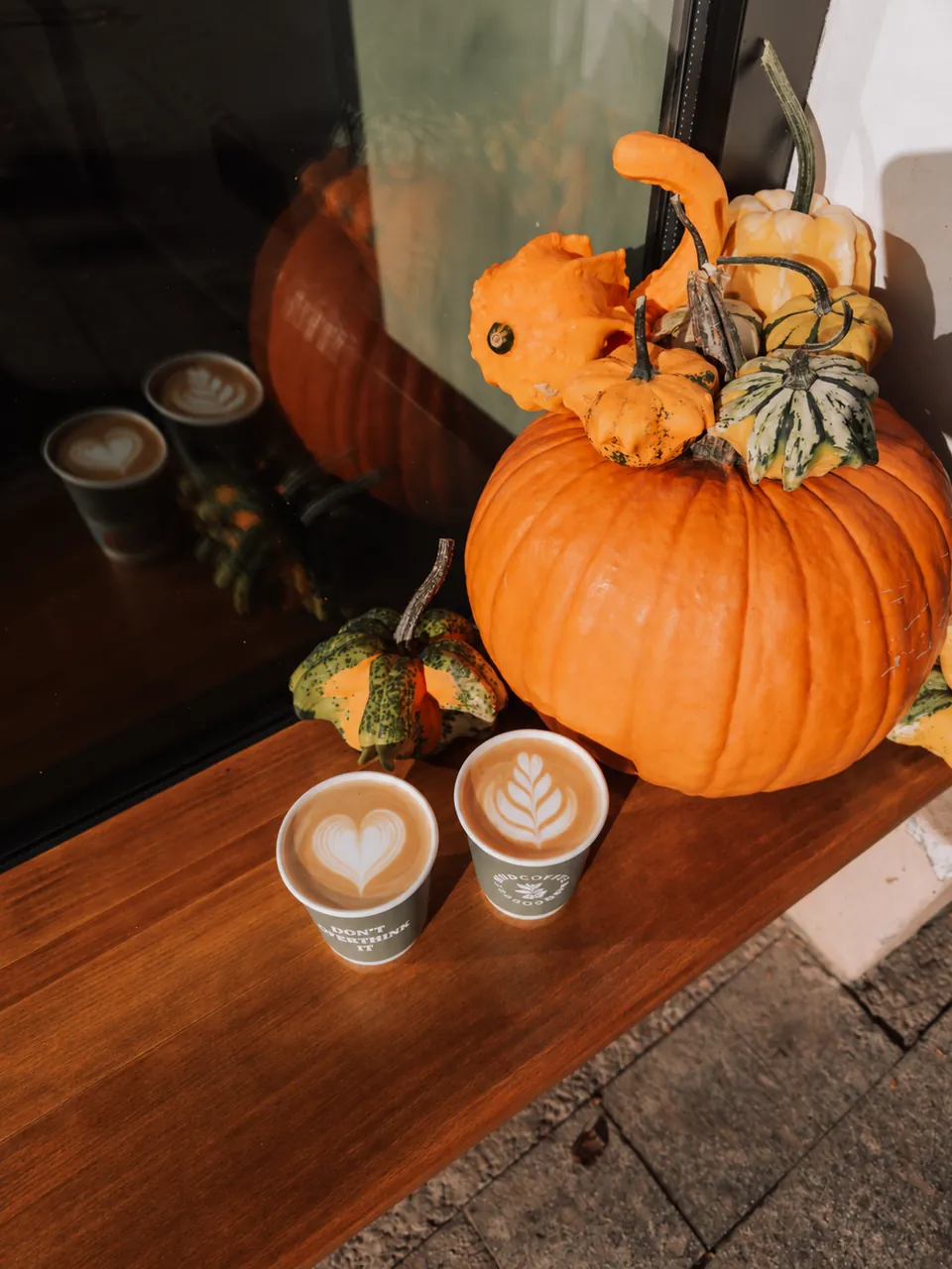 Două latte lângă decorul de toamnă de la MUD