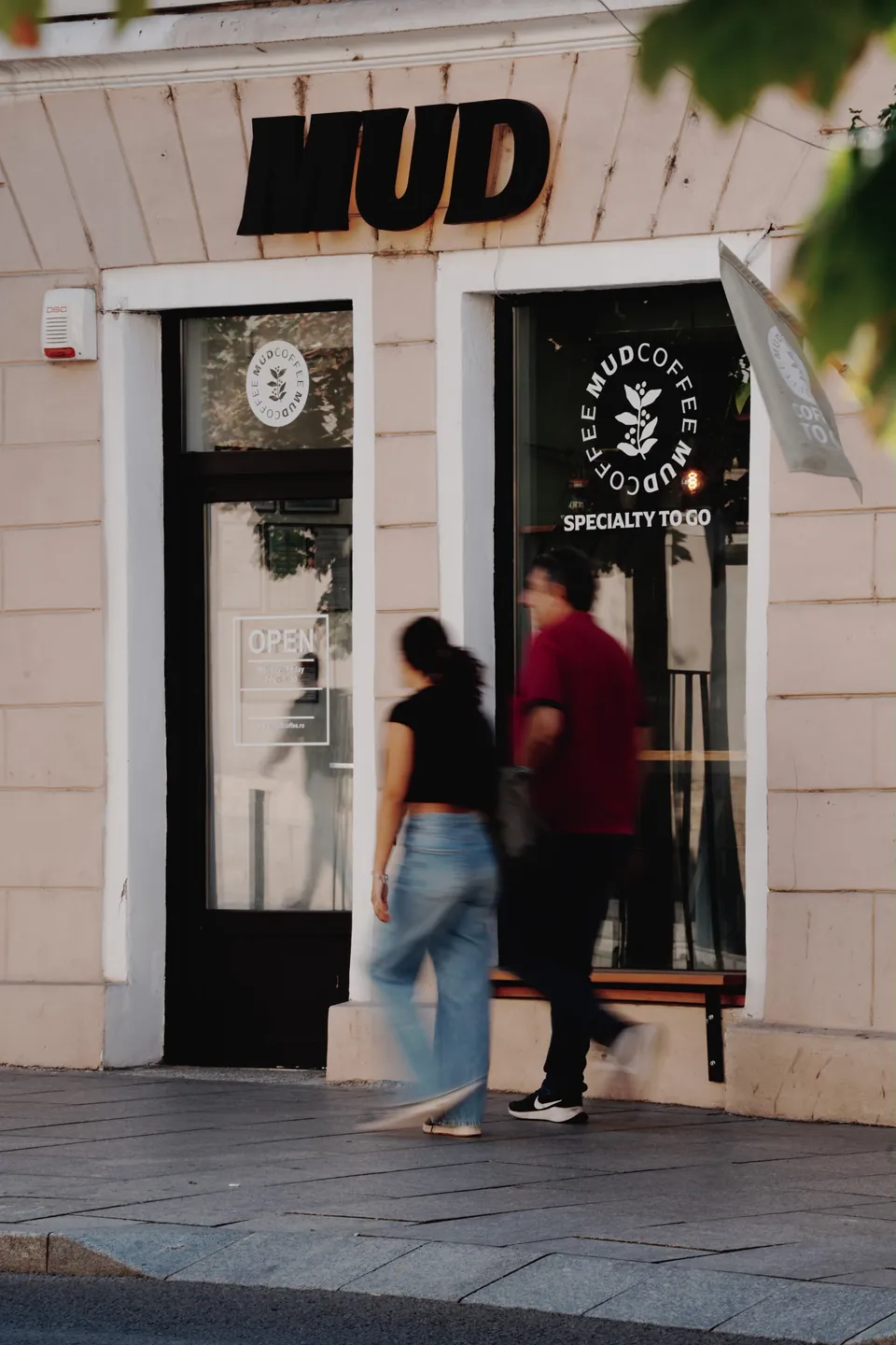 Fațada cafenelei MUD de pe Regele Ferdinand 3, cu oameni trecând pe stradă